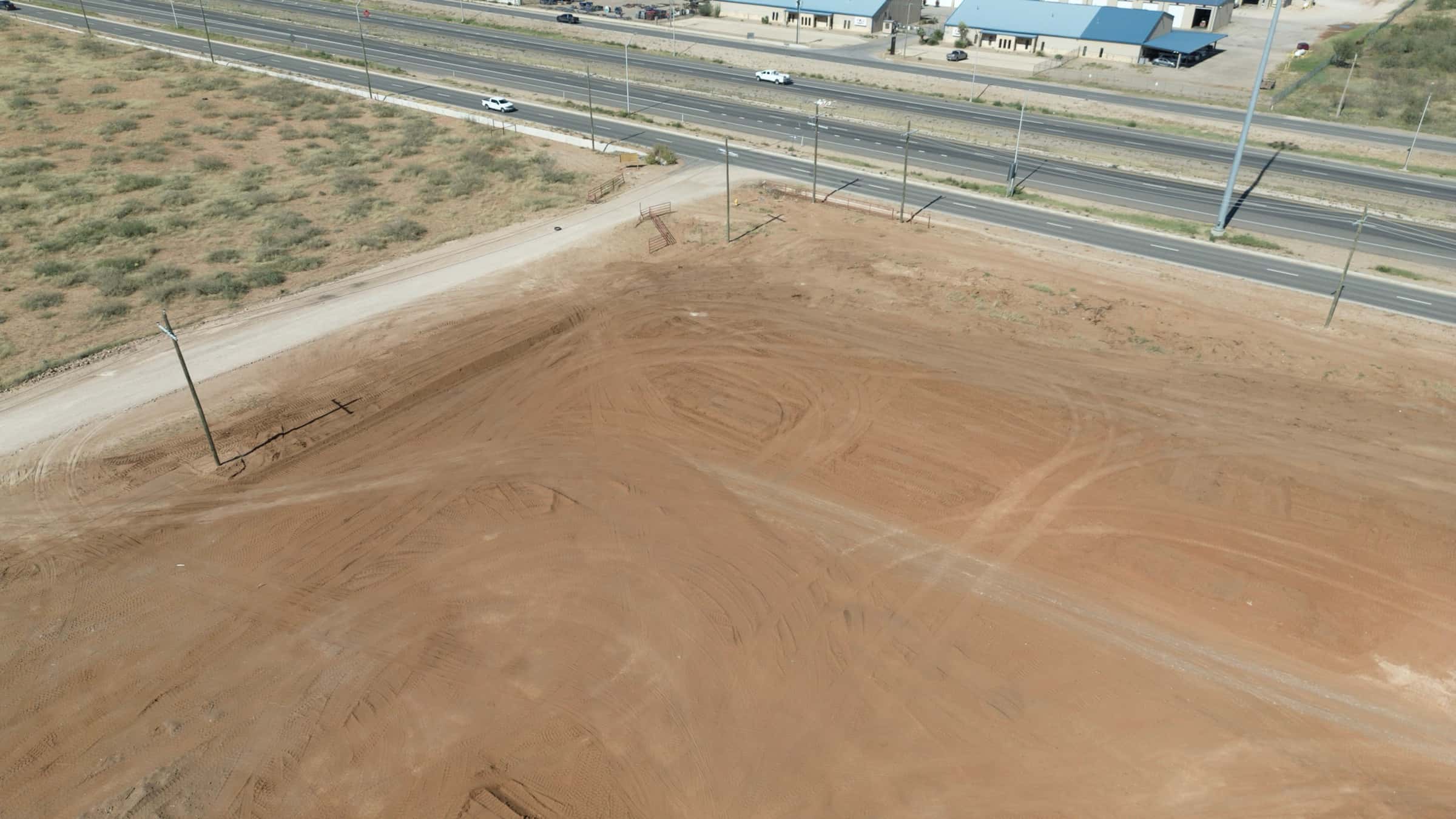 Aerial view of a large graded commercial pad beside a Permian Basin highway