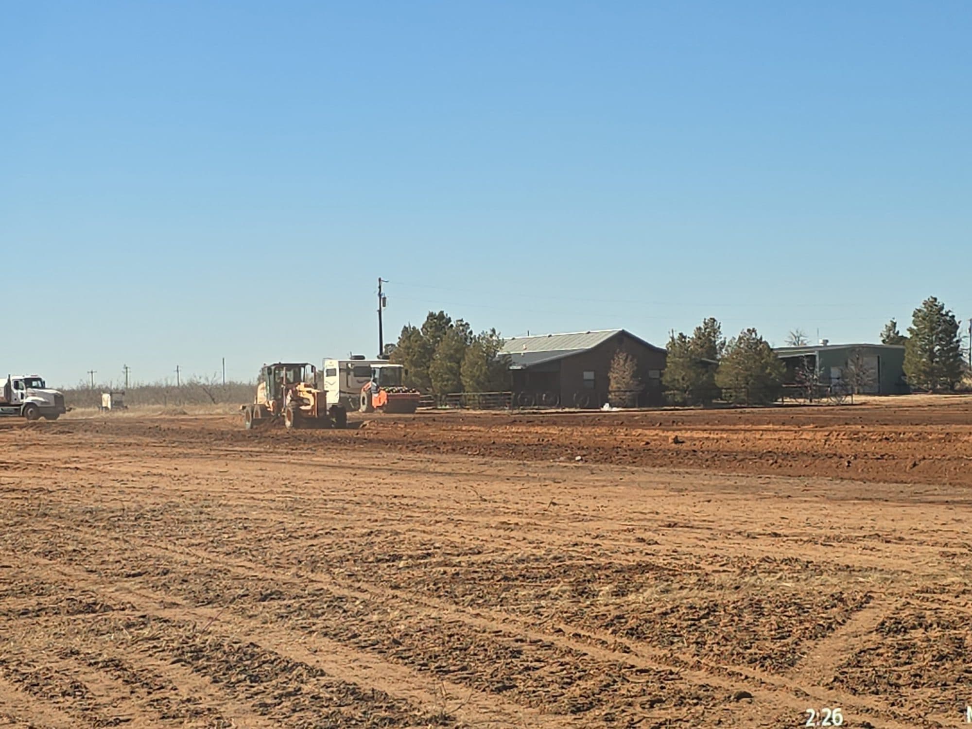 Scraper stripping topsoil and grubbing a tract ahead of construction