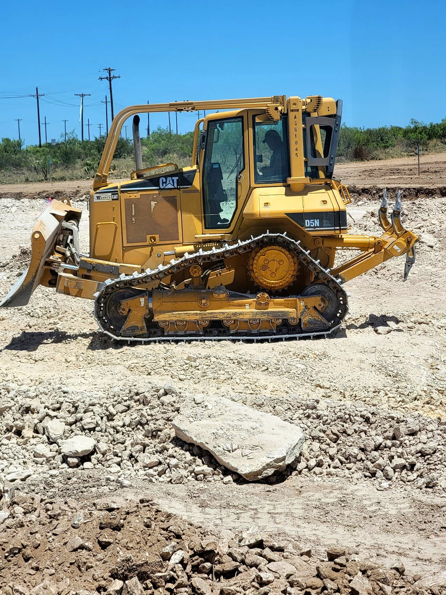 CAT D5N XL dozer with rock rake on a West Texas job site