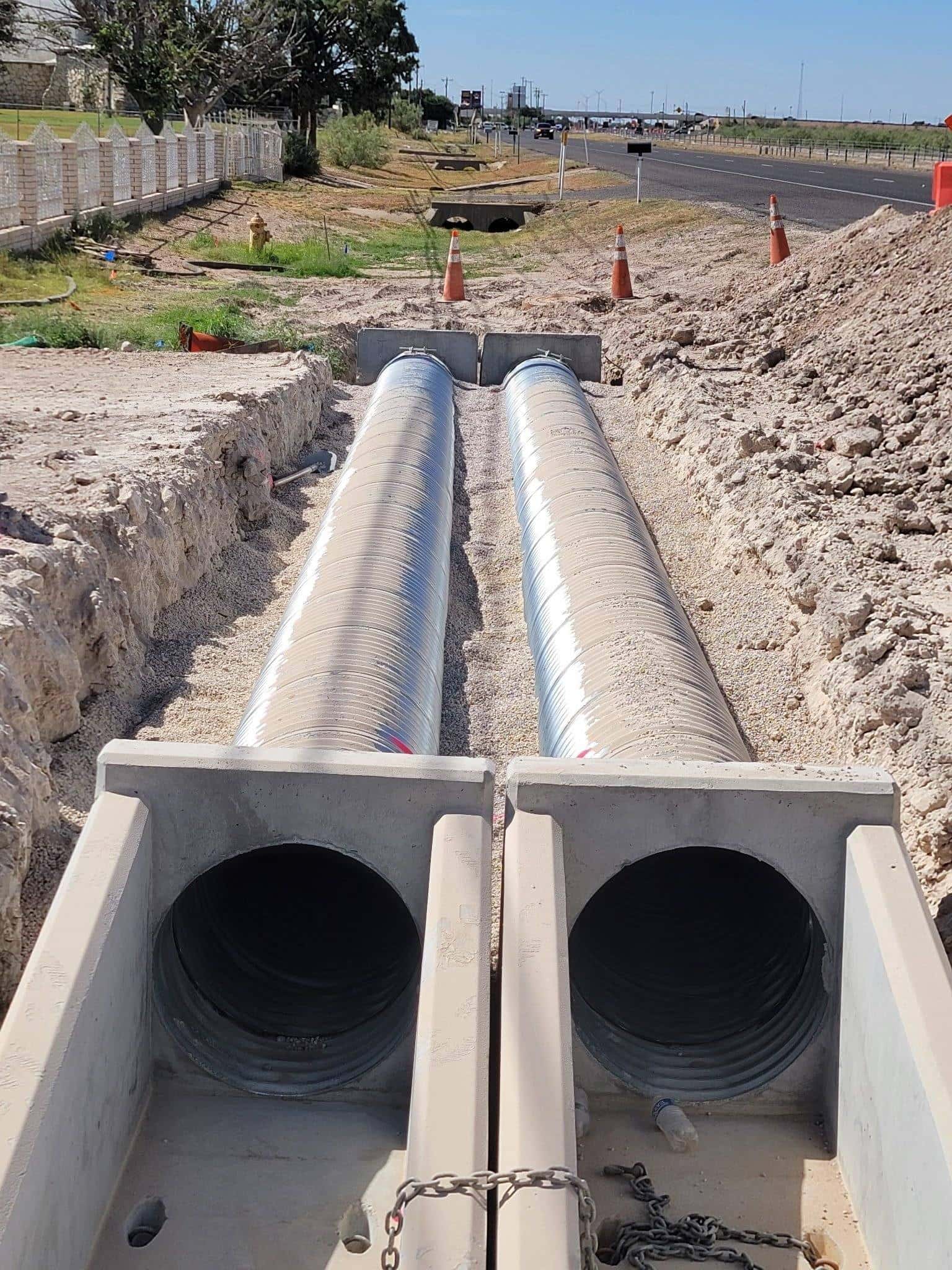 Twin culvert pipes being installed under a ranch road crossing in West Texas