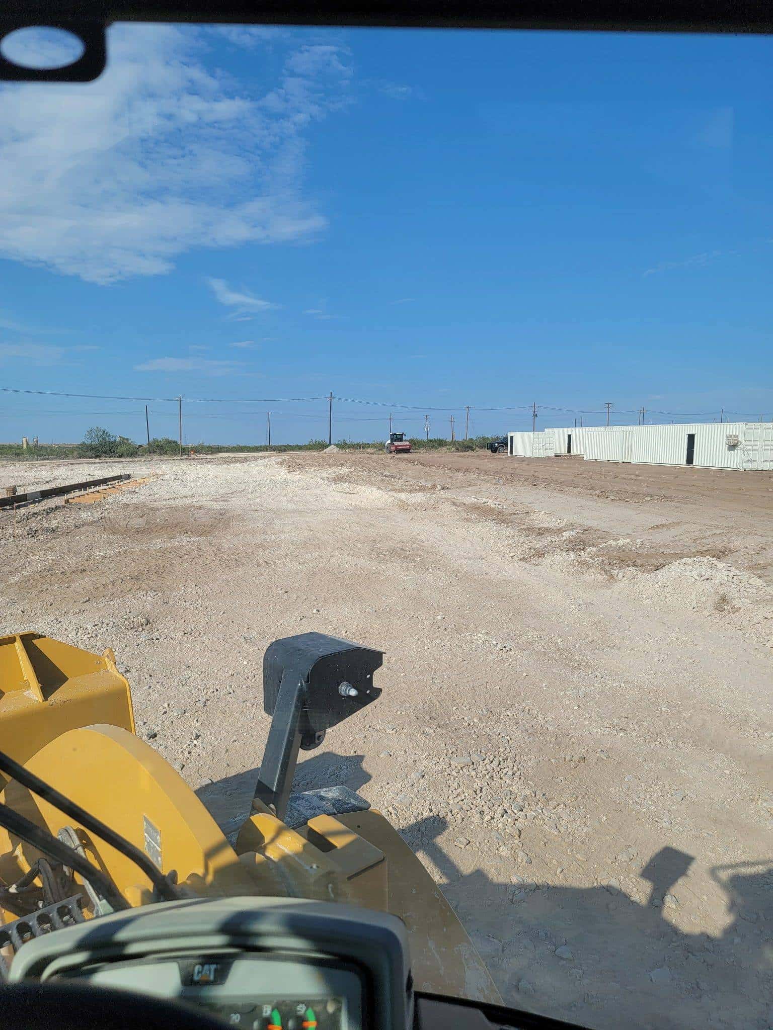 Excavator against a wide Permian Basin sky