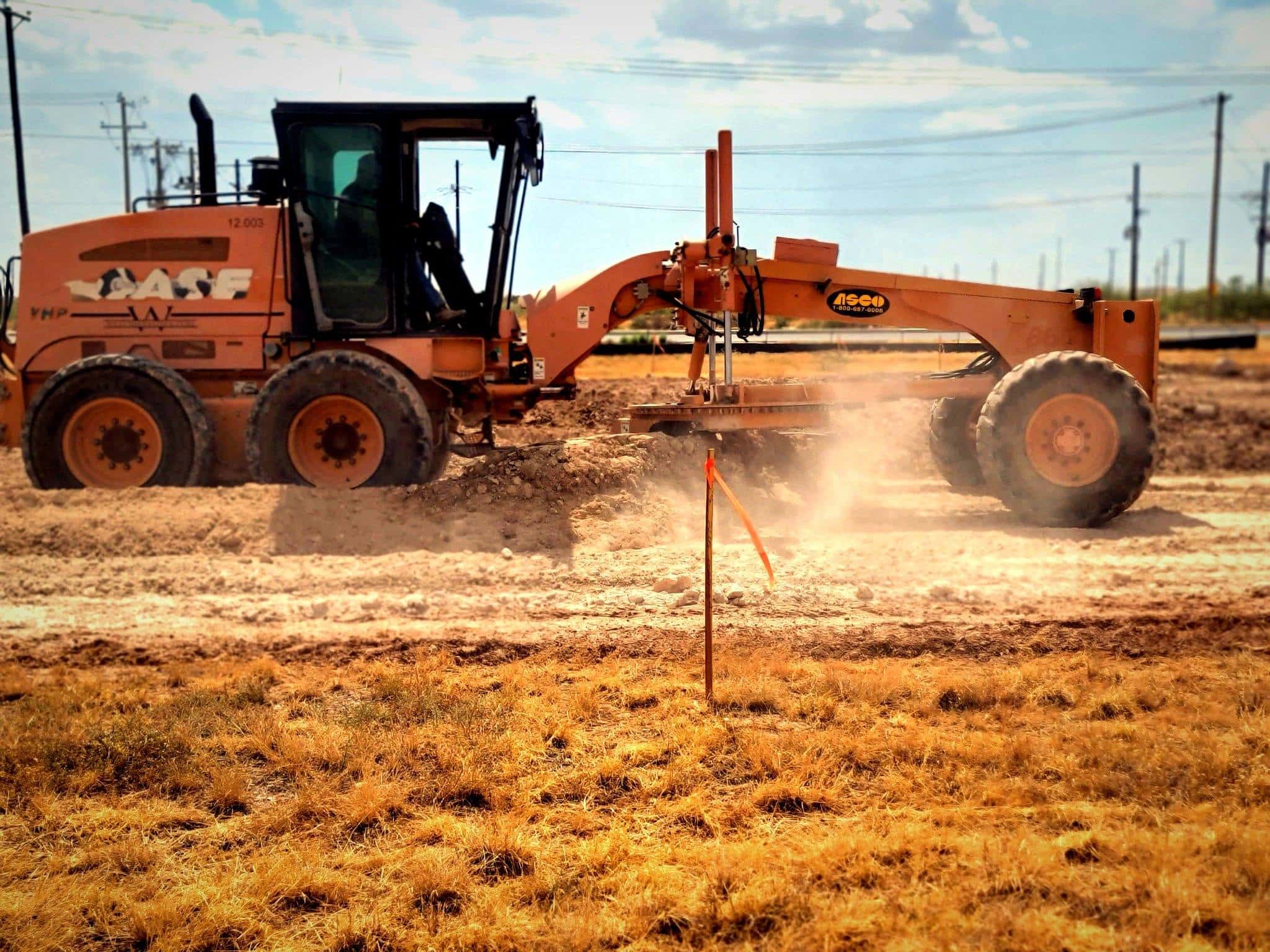 Motor grader cutting a road on a Midland, TX job site