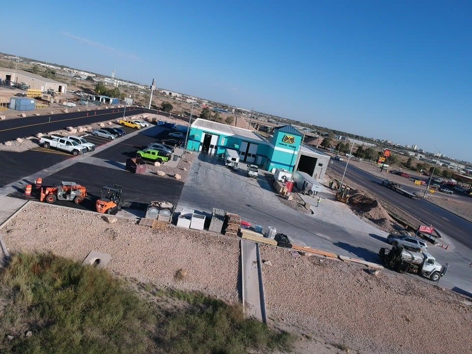 Aerial view of the finished asphalt lot striped and open, with parking laid out