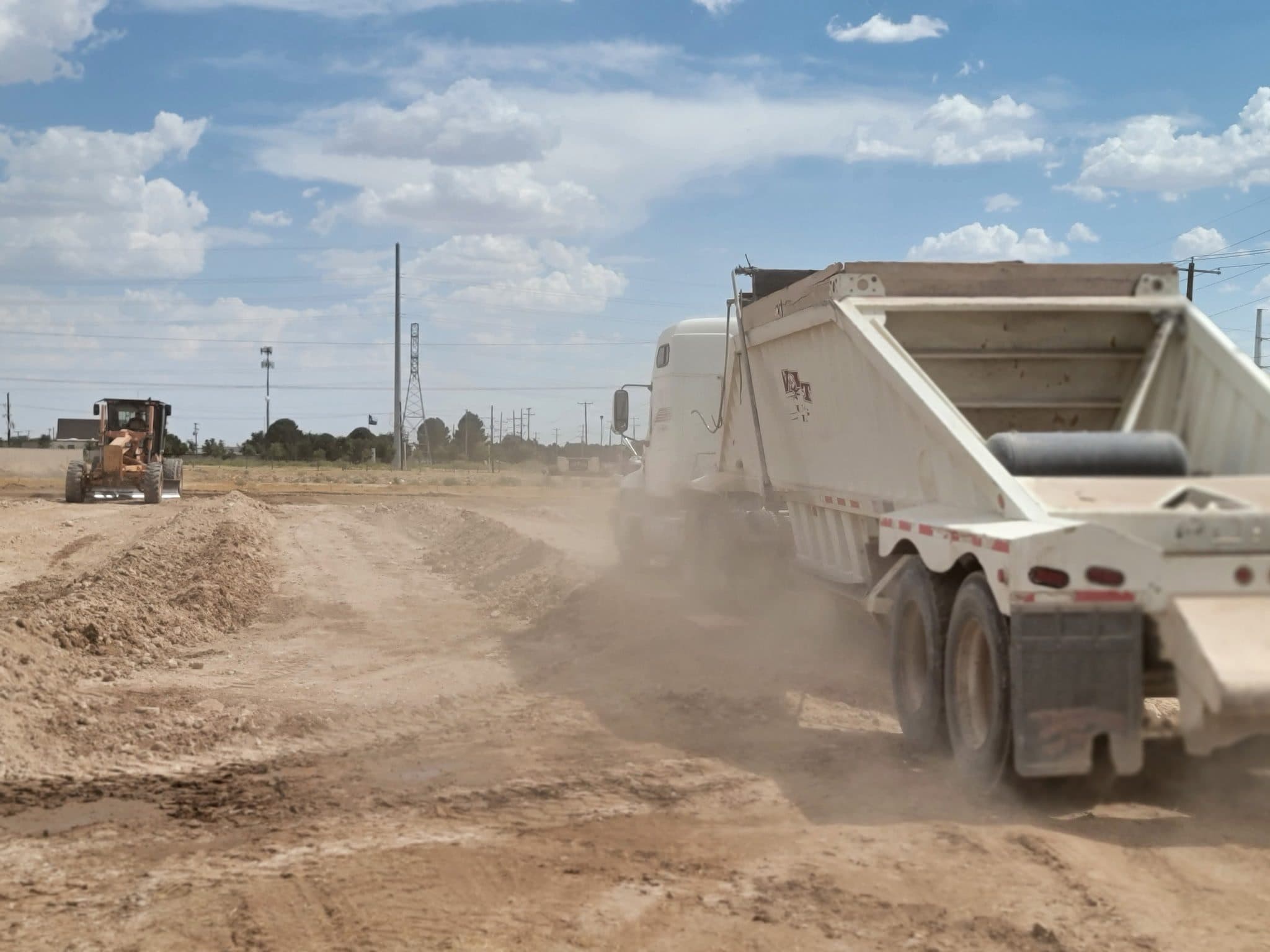 Dump truck hauling base material on a ranch road